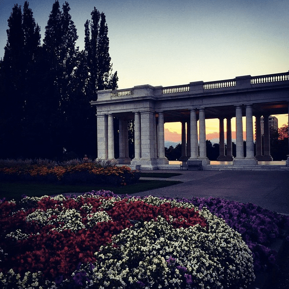 cheesman park pavilion at sunset with beds of flowers in the foreground